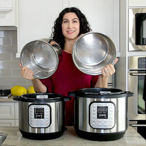 Photo of a woman holding up the insert pots of her Instant Pot pressure cookers.