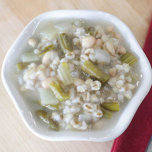 Bean and barley soup in a small bowl on a table